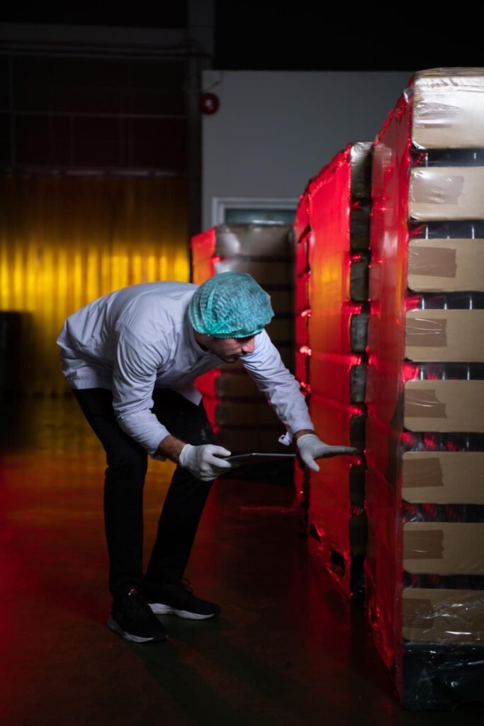 Warehouse worker inspecting wrapped pallets before shipment